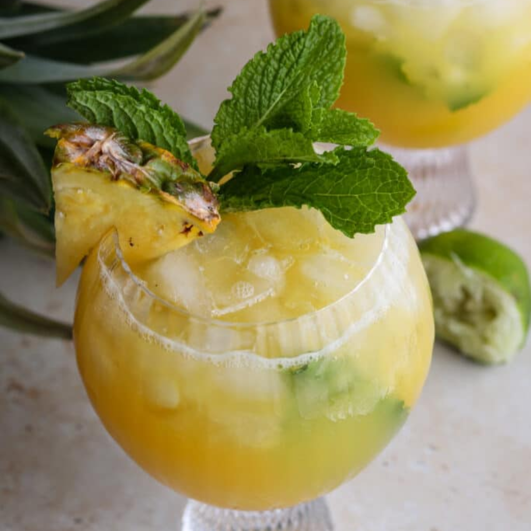 healthy tropical mocktail with fresh mint and pineapple wedge 